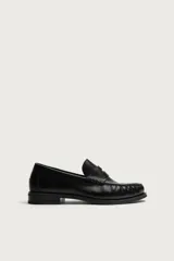 Mocasín de vestir color marrón oscuro, fabricado en cuero, con detalle de antifaz en el empeine y suela a tono con ligero tacón.