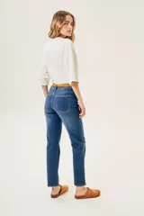 Pantalón de jean azul de corte recto, tiro alto y largo hasta el tobillo.