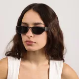 Lentes de sol con armazón de metal en color gris oscuro y cristales oscuros. Presentan un diseño rectangular con líneas definidas y un estilo moderno.