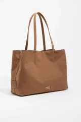 Bolso shopper de tamaño grande confeccionado en nylon, con estructura blanda, doble asa de hombro y logo metálico de la marca en el frente. Incluye bolsillo interior y cierre con mosquetón.