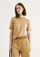 Blusa color beige de tejido de punto, con cuello redondo y mangas cortas.