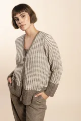 Cardigan tejido de lana color beige con diseño de waffle en blanco.