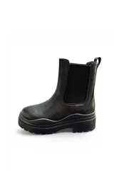 Bota Chelsea de cuero sintético negro, de caña baja con paneles elásticos laterales y suela track gruesa con plataforma y taco cuadrado.