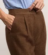 Pantalón de vestir gris con textura tweed, de corte recto, cintura alta con pliegues delanteros y bolsillos laterales.