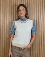 Chaleco tejido de punto 100% algodón, color crudo con detalles en tono tostado en el cuello redondo, sisas y dobladillo inferior.