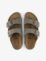 Sandalias Birkenstock modelo Arizona en color gris, con dos correas ajustables de Birko-Flor con acabado tipo nubuc y hebillas metálicas. Cuentan con una base anatómica de corcho y látex, plantilla de ante y suela de EVA.