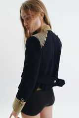 Chaqueta estilo militar de la ZW Collection, color negro con detalles en terciopelo beige y alamares dorados a contraste. Posee cuello subido, manga larga con puños de terciopelo y botones metálicos en relieve.