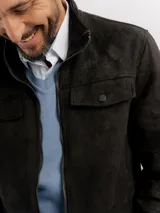 Campera de estilo casual confeccionada en tejido suave con textura tipo gamuza. Presenta cuello alto, cierre frontal, bolsillos laterales y bolsillos frontales con solapa. Incluye detalles de costuras en las mangas y terminaciones elastizadas en puños y cintura.