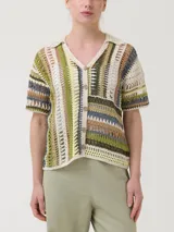 Sweater de crochet modelo Lenka, confeccionado con mezcla de algodón orgánico y lino. Presenta diseño de rayas verticales en la parte superior y horizontales en la inferior, con cuello camisero, mangas cortas y cierre frontal de botones.