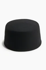 Sombrero tipo pillbox de lana afieltrada en color negro, con diseño minimalista y estructura rígida.