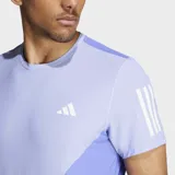 Remera de running Adidas de manga corta, con cuello redondo y corte clásico. Presenta un diseño colorblock con paneles en dos tonos de lila/violeta y las tres franjas reflectantes en las mangas.