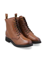 Borcego acordonado de cuero vacuno color suela, con suela de goma negra y cierre lateral. Presenta logo de la marca grabado en el lateral y cordones al tono.
