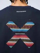 Buzo de cuello redondo color azul marino, con diseño de X bordada en la espalda con estampado étnico multicolor. Cuenta con el logo de la marca estampado en la parte superior de la espalda.