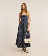 Vestido largo de tricolina con estampado paisley, escote recto sin breteles, corte en la cintura y espalda con lastex.