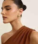 Aros medianos colgantes con baño dorado, base con detalle de hojas texturizadas y colgante de cristal transparente en forma de lágrima facetada.
