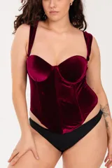 Corset largo con copa y aro, confeccionado en terciopelo bordeaux, con ballenas en la parte delantera, breteles anchos regulables y ganchos reforzados en la espalda.