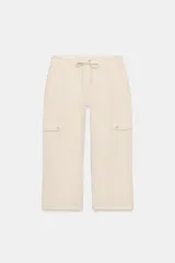 Pantalón capri de tiro medio con bolsillos cargo laterales, cierre frontal con cremallera, botón metálico y cordón ajustable en la cintura.