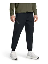 Joggers Under Armour modelo Unstoppable de color negro, confeccionados en tejido técnico elástico con tecnología UA Storm que repele el agua. Presentan corte ajustado en las piernas, cintura elástica con cordón, bolsillos laterales y un bolsillo con cierre sellado en el muslo.