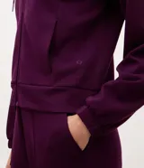 Campera deportiva de modal negro con capucha, cierre frontal por cremallera, cordones ajustables, bolsillos y mangas largas con puños elásticos.