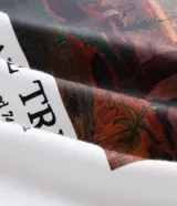Remera de manga corta y cuello redondo, confeccionada en tejido de algodón y poliéster. Presenta un estampado frontal artístico inspirado en la obra 'The Large Tree' de Paul Gauguin.