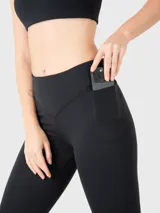 Conjunto deportivo compuesto por un top deportivo de escote en V y calzas de tiro medio con bolsillos laterales, ambos en color negro.