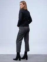 Campera de eco cuero negra, marca Baccini, con cuello con solapa y aplique de tachas. Abertura con cierre metálico cruzado, bolsillos y puños con cierre metálico y forro a tono.