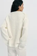 Jersey de punto color crudo, con escote en V pronunciado, mangas largas y acabados en rib.