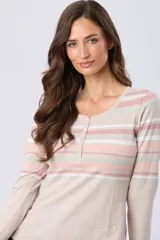 Remera de manga larga con cuello redondo y cierre frontal parcial con botones. Presenta un diseño de rayas horizontales en tonos pastel en la parte superior y un detalle de abertura lateral en el ruedo.