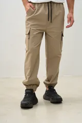 Pantalón cargo color beige con bolsillos laterales con cierre y tobillos elastizados.