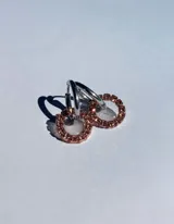 Aros tipo argolla dorados con dije circular de resina transparente y strass color fucsia.