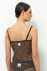 Top negro de encaje sin mangas con lazo de terciopelo en el centro del busto.