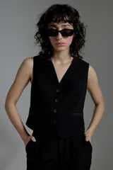 Chaleco negro de corte sastrero con escote en V y cierre frontal con botones.