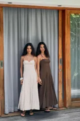 Vestido midi de corte fluido con cuello halter y lazada ajustable. Presenta escote recto y falda con volumen.