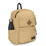 Mochila Jansport modelo Double Break de 27 litros, color beige, con compartimento principal amplio, múltiples bolsillos frontales con cierre, parche de cuero sintético en forma de rombo y etiqueta con el logo de la marca.