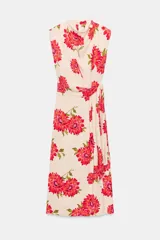 Vestido midi de color beige con estampado floral en tonos rojos y fucsias, con cuello fluido, manga sisa y cinturón del mismo tejido.