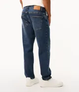 Pantalón de jean corte slim color azul claro con efecto de lavado desgastado. Cuenta con cierre frontal con botón, pasadores para cinturón y bolsillos funcionales.
