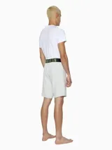 Short de dormir blanco de corte holgado, con cintura elástica negra que lleva el logo de Calvin Klein en verde neón.