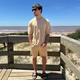 Remera negra tejida con cuello redondo y manga corta, con logo bordado en el pecho.