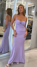 Vestido largo lila con brillo, de corte sirena, escote drapeado con detalle fruncido en el centro del busto y tirantes finos.
