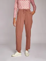 Pantalón de algodón color ladrillo, de corte recto, con cintura elástica ajustable con cordones, dos bolsillos delanteros y falsos bolsillos de vivo en la espalda.