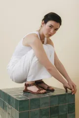 Sandalias negras de cuero con tiras finas, pulsera al tobillo con hebilla metálica y apliques de tachas plateadas.