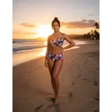 Bikini de dos piezas con estampado floral sobre fondo negro, compuesto por un top con volados y una bombacha de tiro medio con detalles de volados en los laterales.