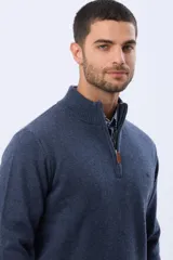 Buzo tejido de lana con cuello alto y medio cierre metálico frontal. Presenta puños y ruedo acanalados, con logo bordado en el pecho.