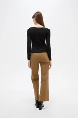 Remera negra de manga larga y calce al cuerpo, confeccionada en poliéster con diseño calado y escote en V.