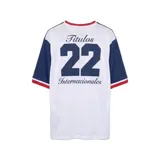 Remera de fútbol Umbro del Club Nacional de Football, modelo Match en color azul marino con mangas y canesú rojos. Cuenta con cuello en V con detalles blancos y azules, y el escudo del club bordado en el pecho.