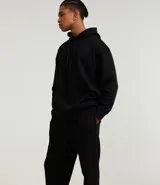 Pantalón jogger negro de algodón y poliéster, con cintura elástica y cordón ajustable. Presenta bolsillos laterales y puños ajustados en los tobillos.