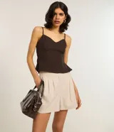 Short de sastrería color beige, con pliegues delanteros, trabillas en la cintura y bolsillos laterales.
