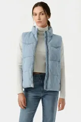 Chaleco puffer de estilo western con diseño acolchado, cuello alto y cierre frontal con cremallera. Presenta un acabado en tono celeste lavado.
