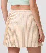 Short pollera deportivo de microfibra color beige, con diseño plisado y cintura elastizada con cordón regulable.