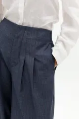 Pantalón de corte culotte extra ancho, tiro alto con pinzas frontales y cierre oculto. Confeccionado en tejido twill de color azul oscuro con textura sutil.